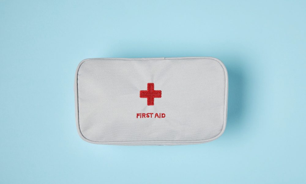 top view of white first aid kit bag on blue surface